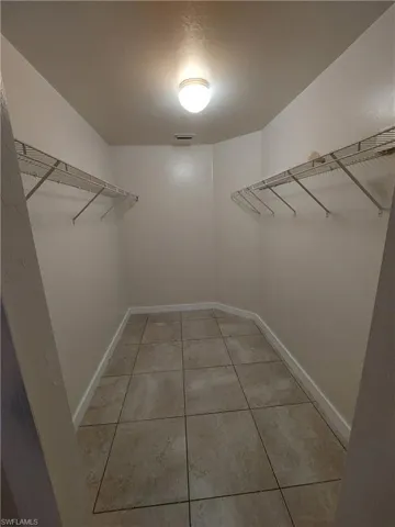 Walk in closet with light tile patterned flooring