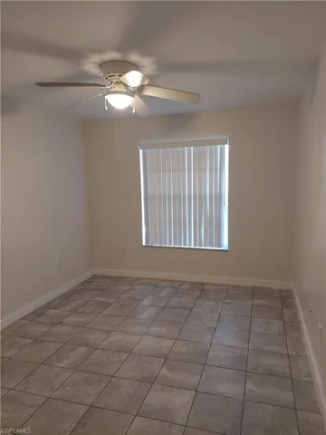 Unfurnished room with a ceiling fan and light tile patterned floors