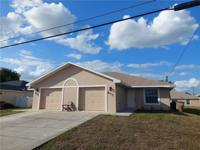 Ranch-style home with stucco siding, a front yard, and a garage