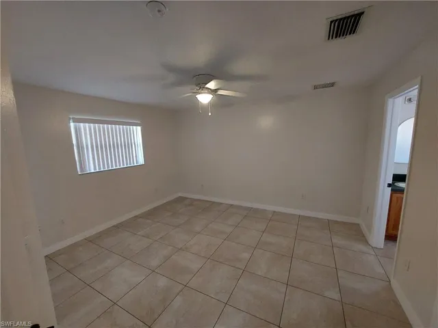 Spare room featuring light tile patterned floors and ceiling fan
