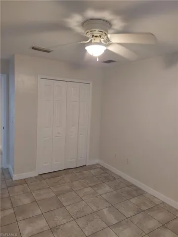 Unfurnished bedroom featuring ceiling fan, a closet, and light tile patterned floors