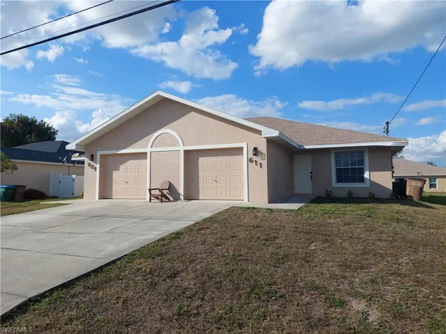 Ranch-style home featuring stucco siding, an attached garage, a front lawn, and concrete driveway
