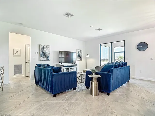 Living area featuring baseboards and visible vents