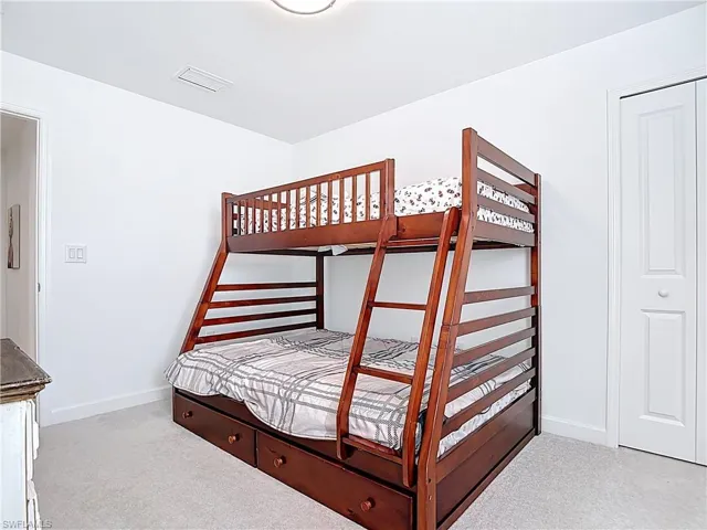 Carpeted bedroom with baseboards and visible vents