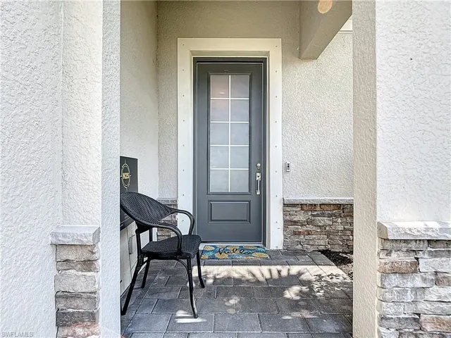 Entrance to property with stucco siding and stone siding