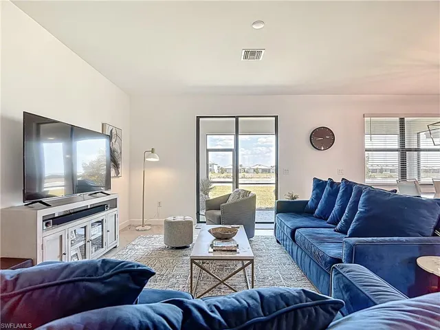 Living area featuring baseboards, visible vents, and a healthy amount of sunlight