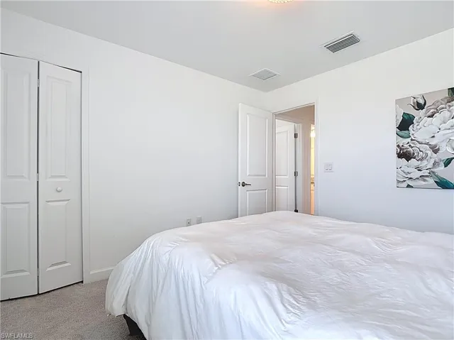 Bedroom featuring visible vents, carpet, and baseboards