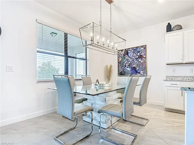 Dining room featuring baseboards and a notable chandelier