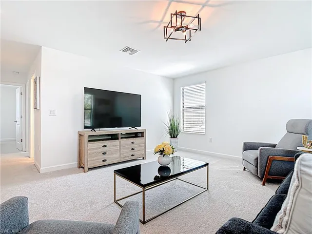 Carpeted living area with visible vents and baseboards