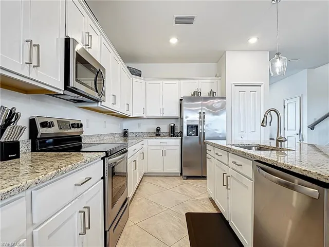 Kitchen featuring visible vents, a sink, white cabinetry, and appliances with stainless steel finishes