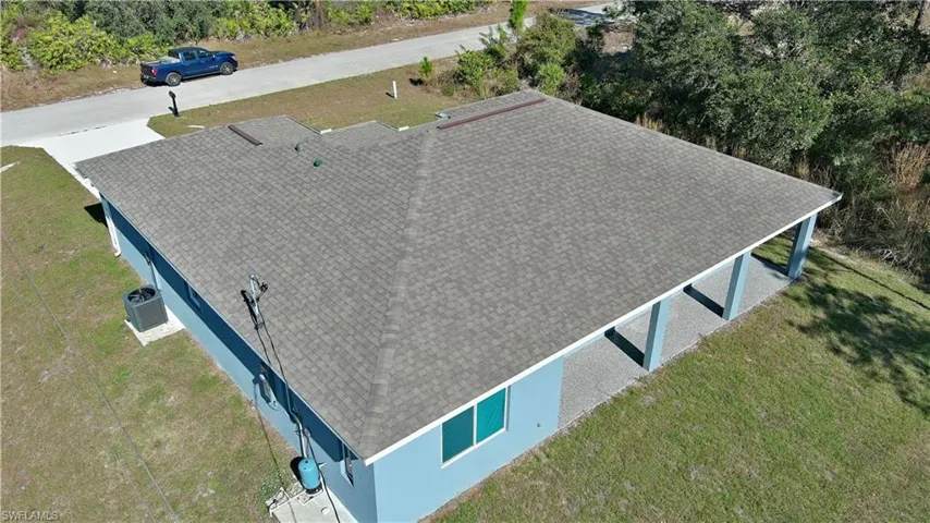 Pitched shingle roof with an extended covered patio featuring supporting columns