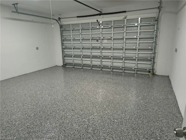 Garage featuring an epoxy-coated floor and an overhead garage door