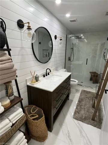 White shiplap accent wall with dual globe sconces