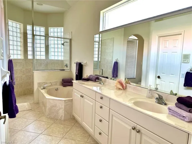 En suite features separate soaking tub, walk-in shower, private water closet, and linen closet