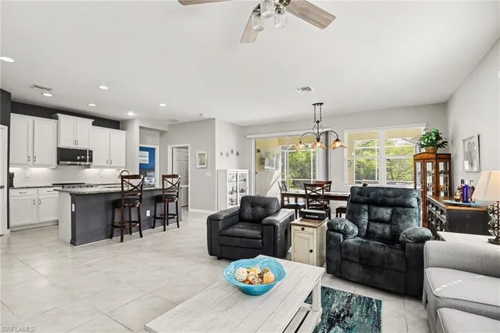 Living area featuring ceiling fan, hanging lights, and light tile patterned floors