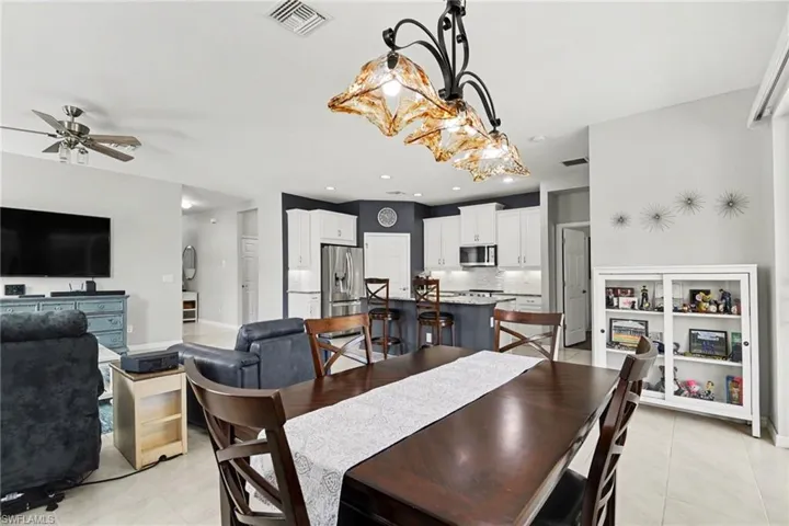 Dining area with light tile patterned floors, ceiling fan, and recessed lighting