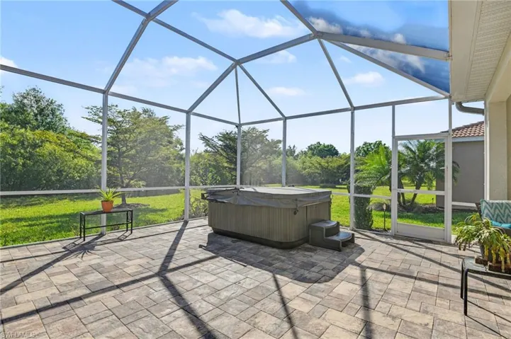 View of patio with a sunroom, a lanai, and a hot tub