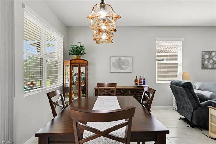 Dining area with suspended lighting and light tile patterned flooring