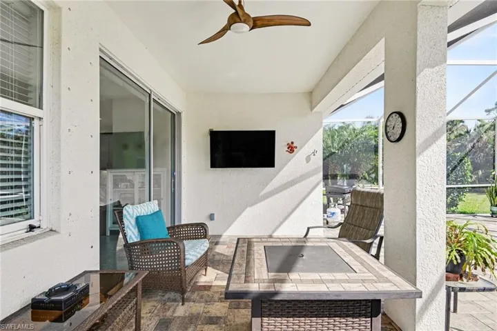 View of patio with ceiling fan, a lanai, and an outdoor fire pit