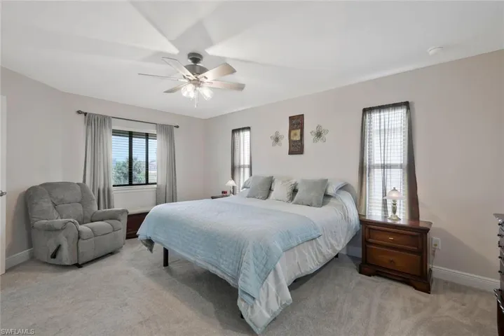 Bedroom with a ceiling fan and light carpet