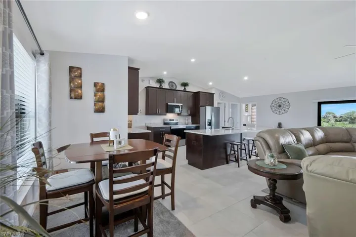 Dining space with lofted ceiling and recessed lighting