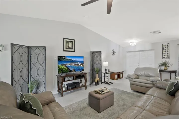 Living area with ceiling fan and lofted ceiling