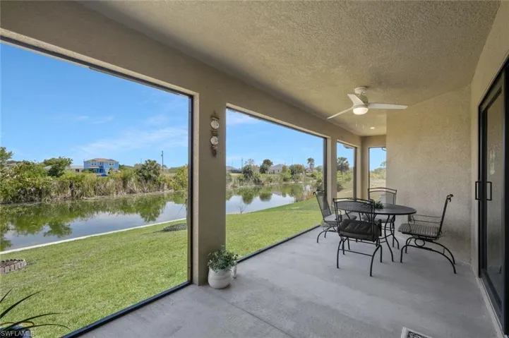 Sunroom featuring concrete floors, a textured ceiling, and a water view