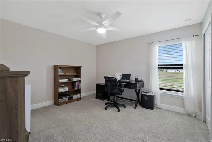 Office space featuring light colored carpet and ceiling fan