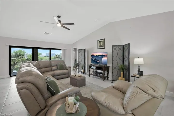 Living room featuring lofted ceiling and a ceiling fan