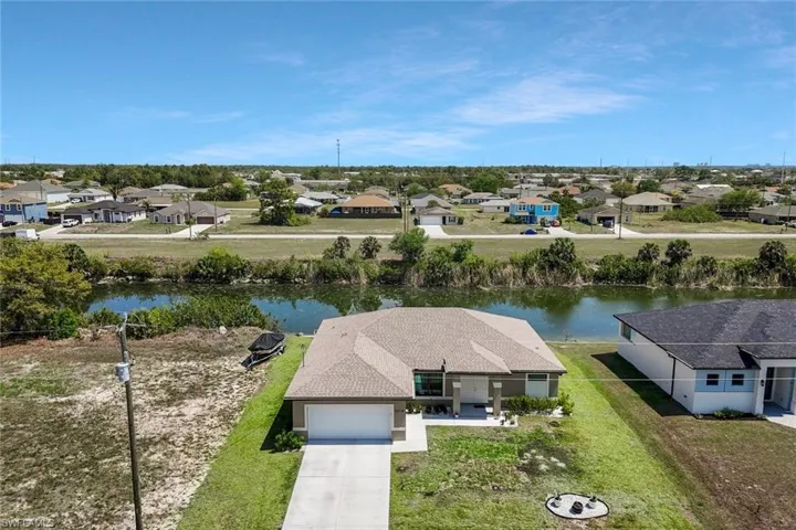 Aerial view of residential area featuring a nearby body of water