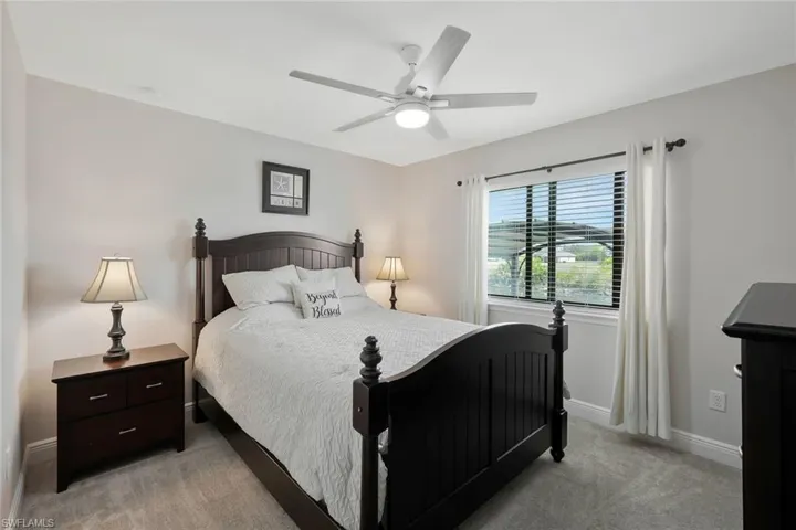 Bedroom featuring a ceiling fan and light colored carpet