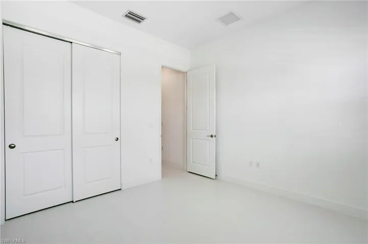 Unfurnished bedroom featuring a closet, baseboards, and visible vents