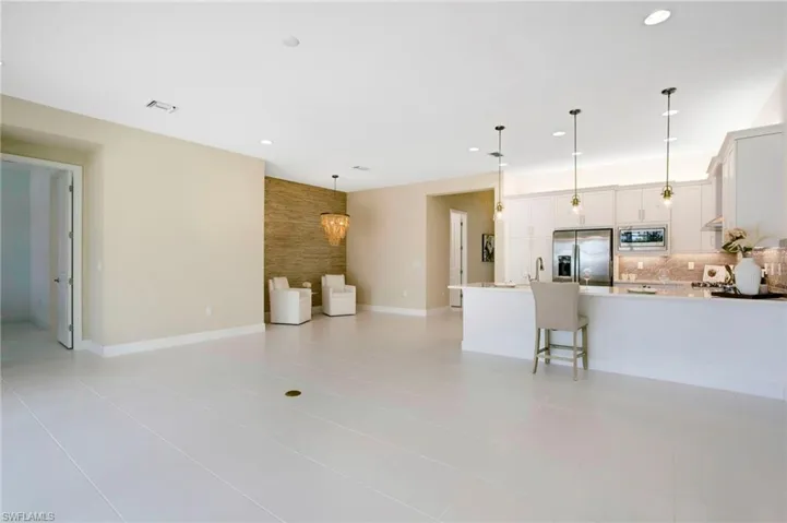Living room featuring light tile patterned floors, recessed lighting, and visible vents