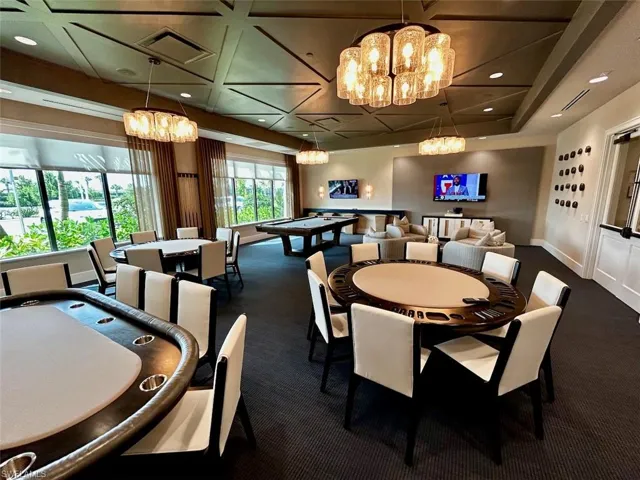 Carpeted dining space with baseboards, visible vents, and an inviting chandelier