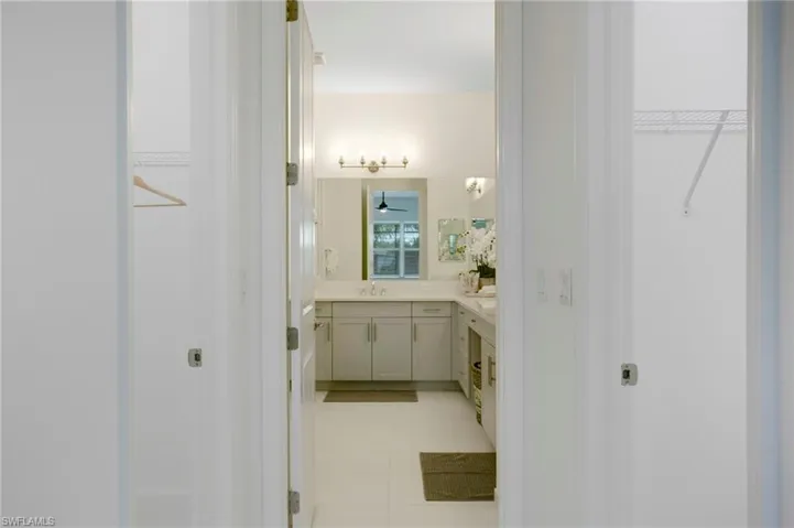 Bathroom with a spacious closet, tile patterned floors, and vanity