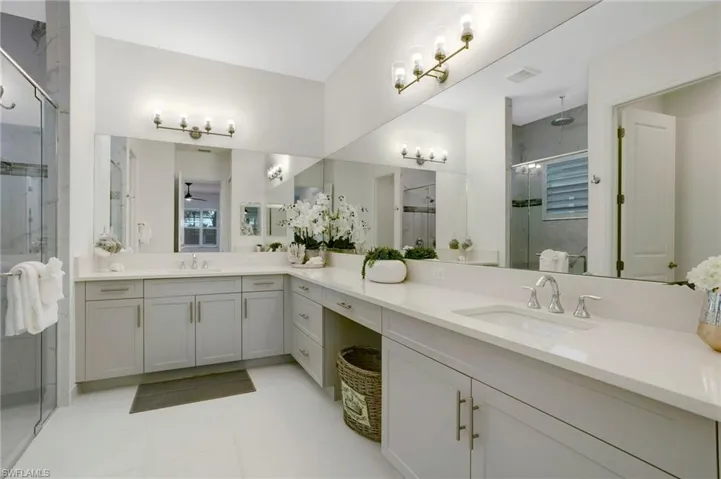 Bathroom with a stall shower, visible vents, tile patterned flooring, and vanity