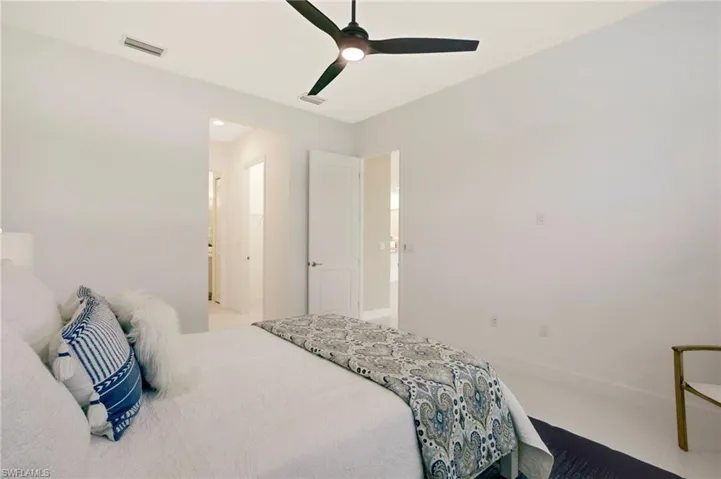 Bedroom with baseboards, visible vents, and a ceiling fan