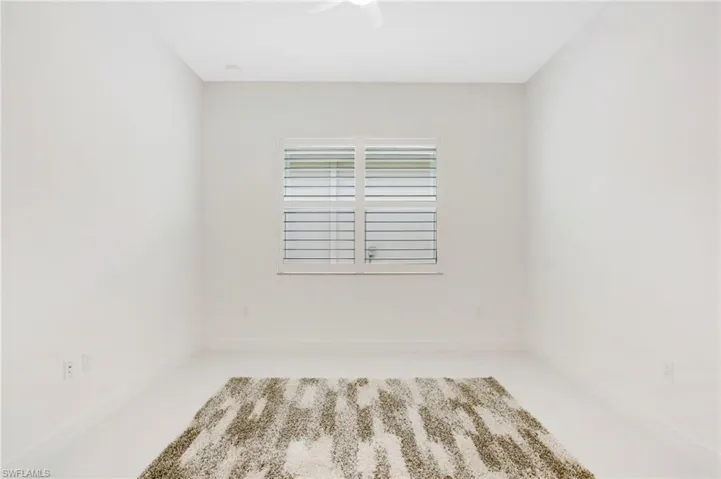 Unfurnished room featuring a ceiling fan and baseboards
