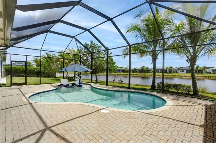 Pool featuring a lanai, a water view, and a patio area