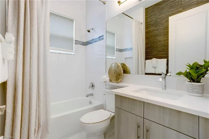 Full bathroom featuring shower / tub combo with curtain, toilet, and vanity