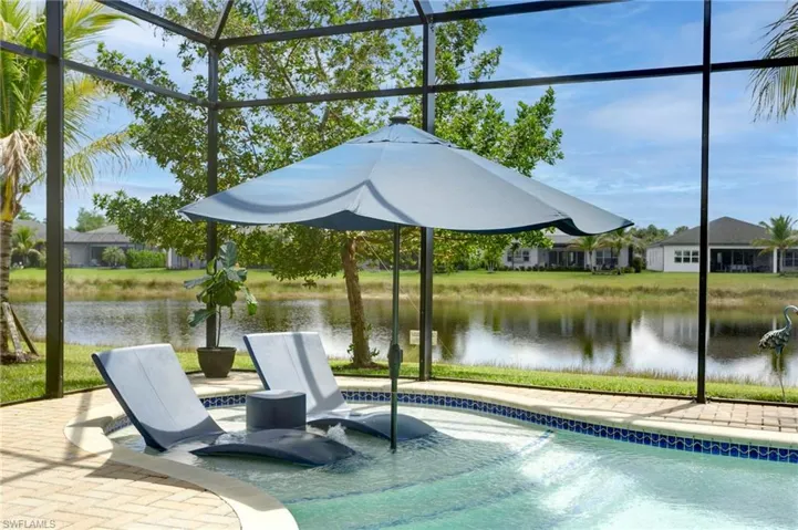 View of pool with a water view and a lanai