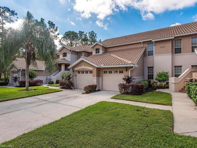 Mediterranean / spanish home with stucco siding, driveway, a tiled roof, and a front lawn