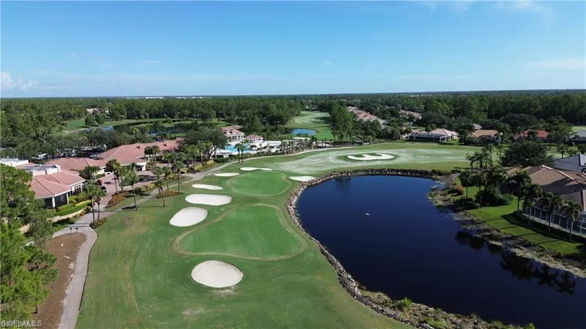 View of property location with a golf club, a large body of water, and nearby suburban area