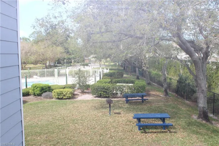 View from 2nd Floor Window, View of yard with a community pool and fence
