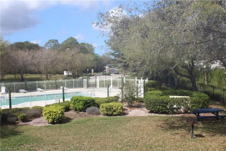 View from 2nd Floor Window, Pool with fence and a lawn