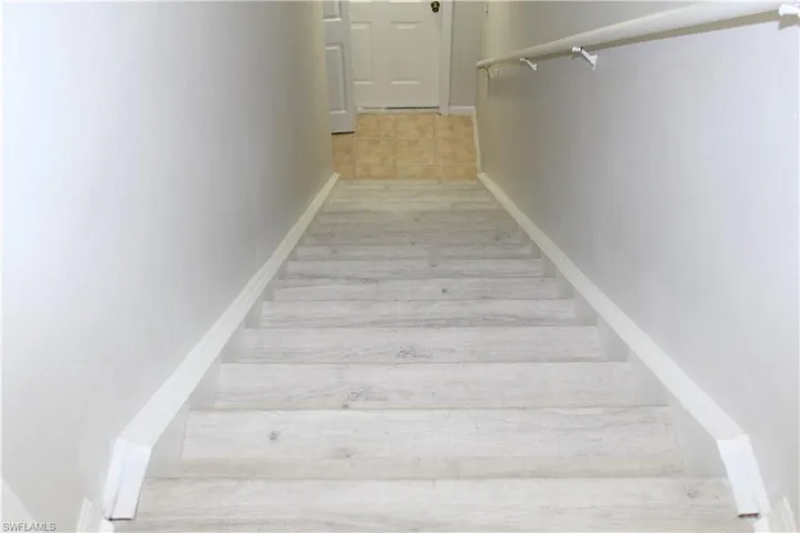 Staircase with baseboards and wood finished floors