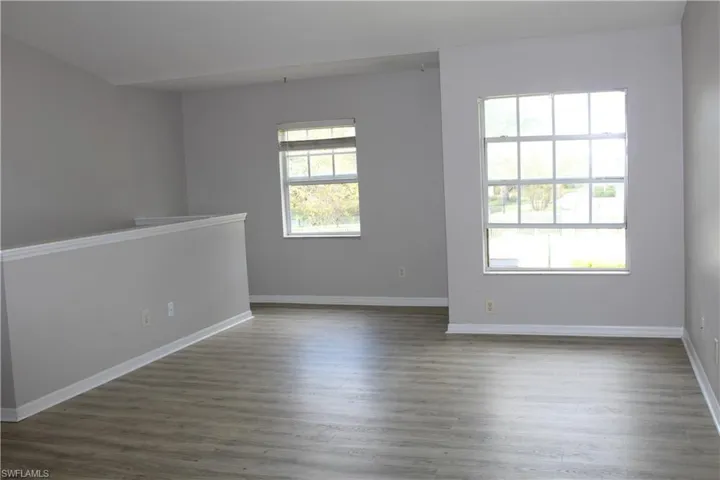 Unfurnished room with dark wood-type flooring and baseboards