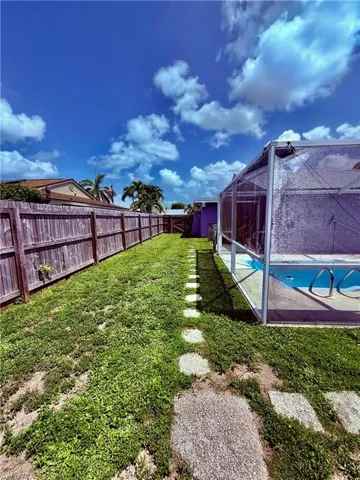 Fenced backyard featuring glass enclosure