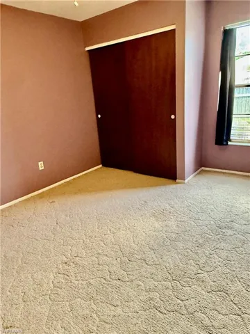 Carpeted spare room featuring baseboards