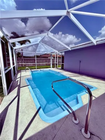 View of swimming pool featuring a fenced backyard, a lanai, and a patio